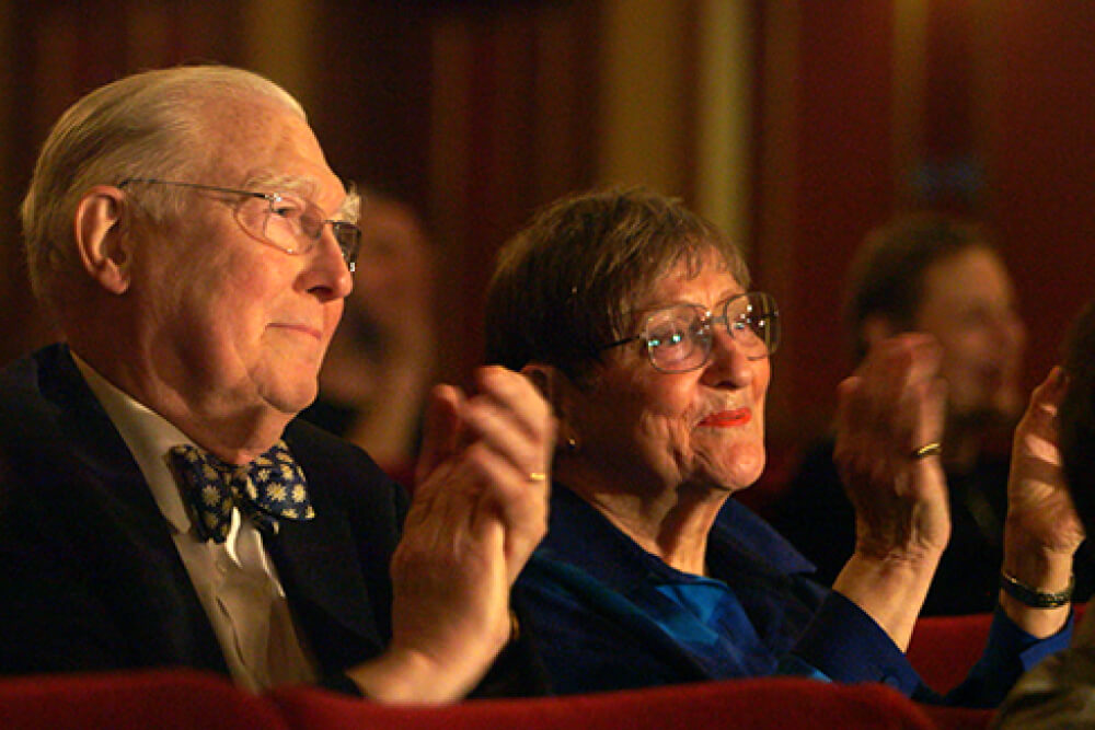 Man and woman clapping in theatre